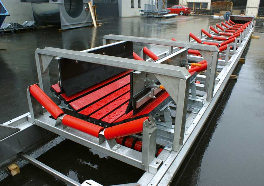 Metallisches Förderband mit roten Rollen und stabiler Rahmenkonstruktion auf einem Industriegelände