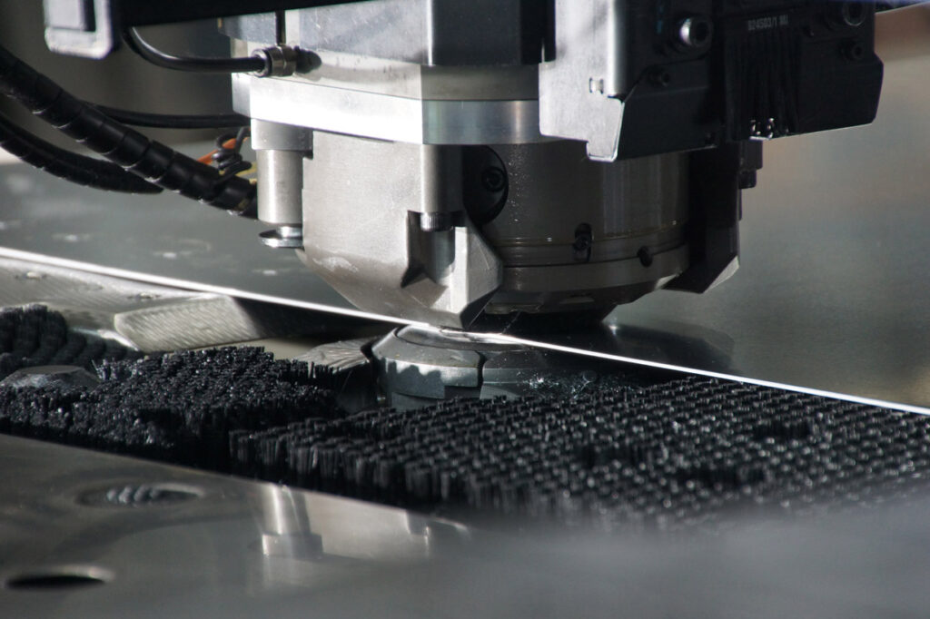 Präzise CNC-Maschine beim Stanzen einer Metallplatte in einer modernen Produktionsumgebung.